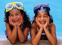 Bild av två unga flickor fnittrande vid sidan av poolen