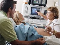 Bild på en läkare som utför ett ultraljud på en blivande modern