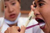 Bild av en tandläkare som instruerar en ung flicka på rätt Tandborstning teknik