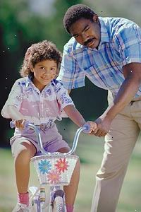 Bild av en far att lära sin dotter att cykla