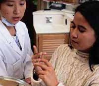 Bild på en ung flicka som instrueras av sin tandläkare om hur du tandtråd