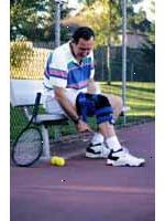 Bild av en man som bär en knä-stag, spela tennis