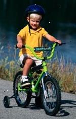 Bild av ung pojke, med en hjälm, cykla