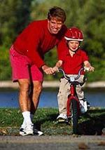 Bild av en far undervisa sin son hur man rider en cykel