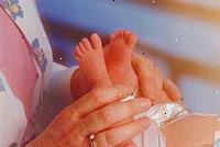Bild av en sjuksköterska undersöker en nyfödd