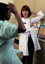 Bild av en kvinnlig läkare att lära patienten hur man utför en självbröstundersökning